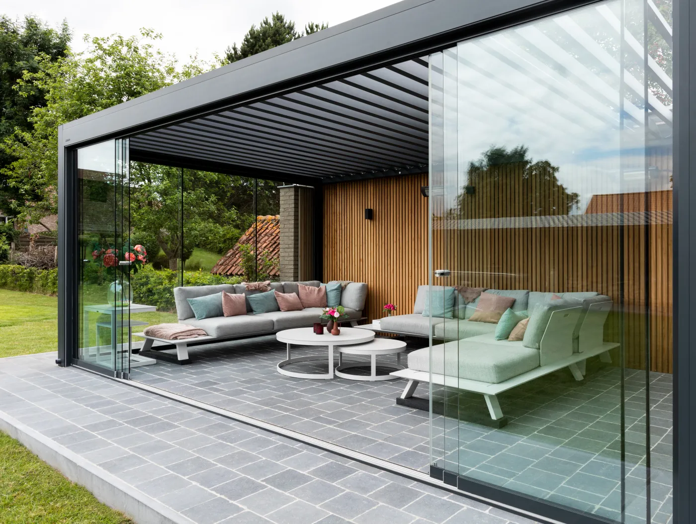 Überdachte Terrassen-Lounge mit Lamellendach und Glasschiebewänden